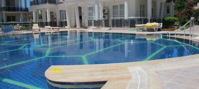 Apartamento en planta baja en un complejo privado con jardines y piscina.